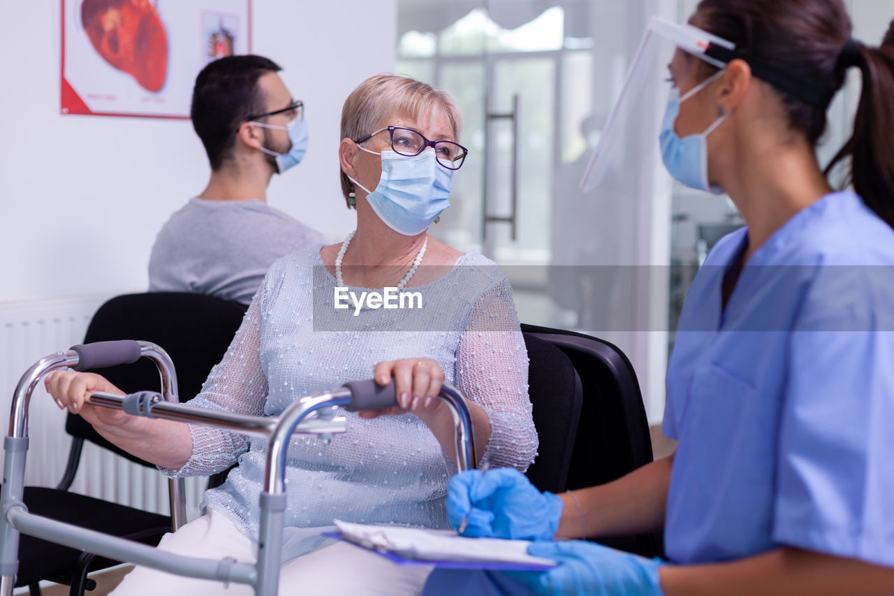 MIDSECTION OF WOMEN WEARING MASK IN BATHROOM