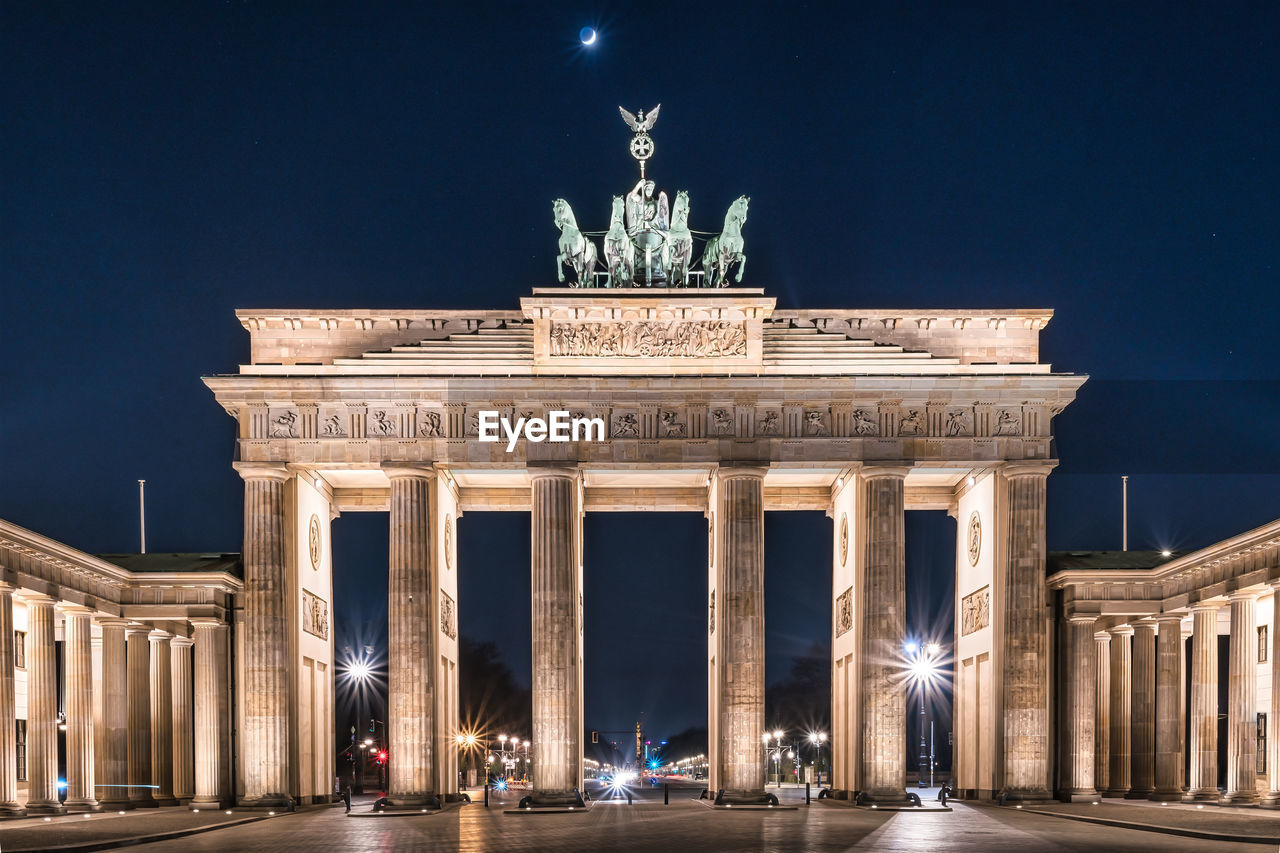 Low angle view of brandenburg gate against clear blue sky at night