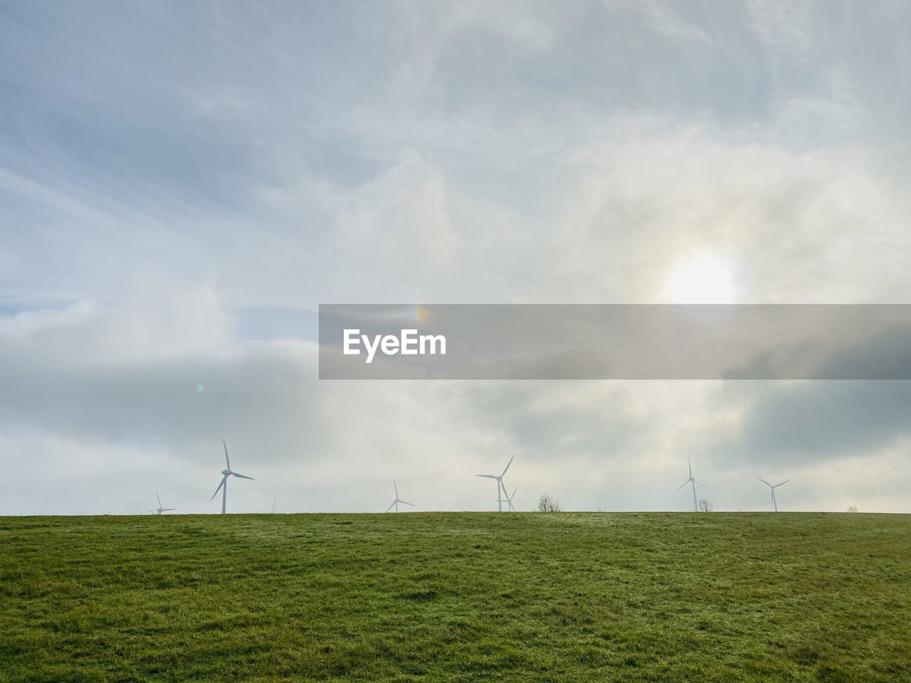 WIND TURBINES ON LAND AGAINST SKY