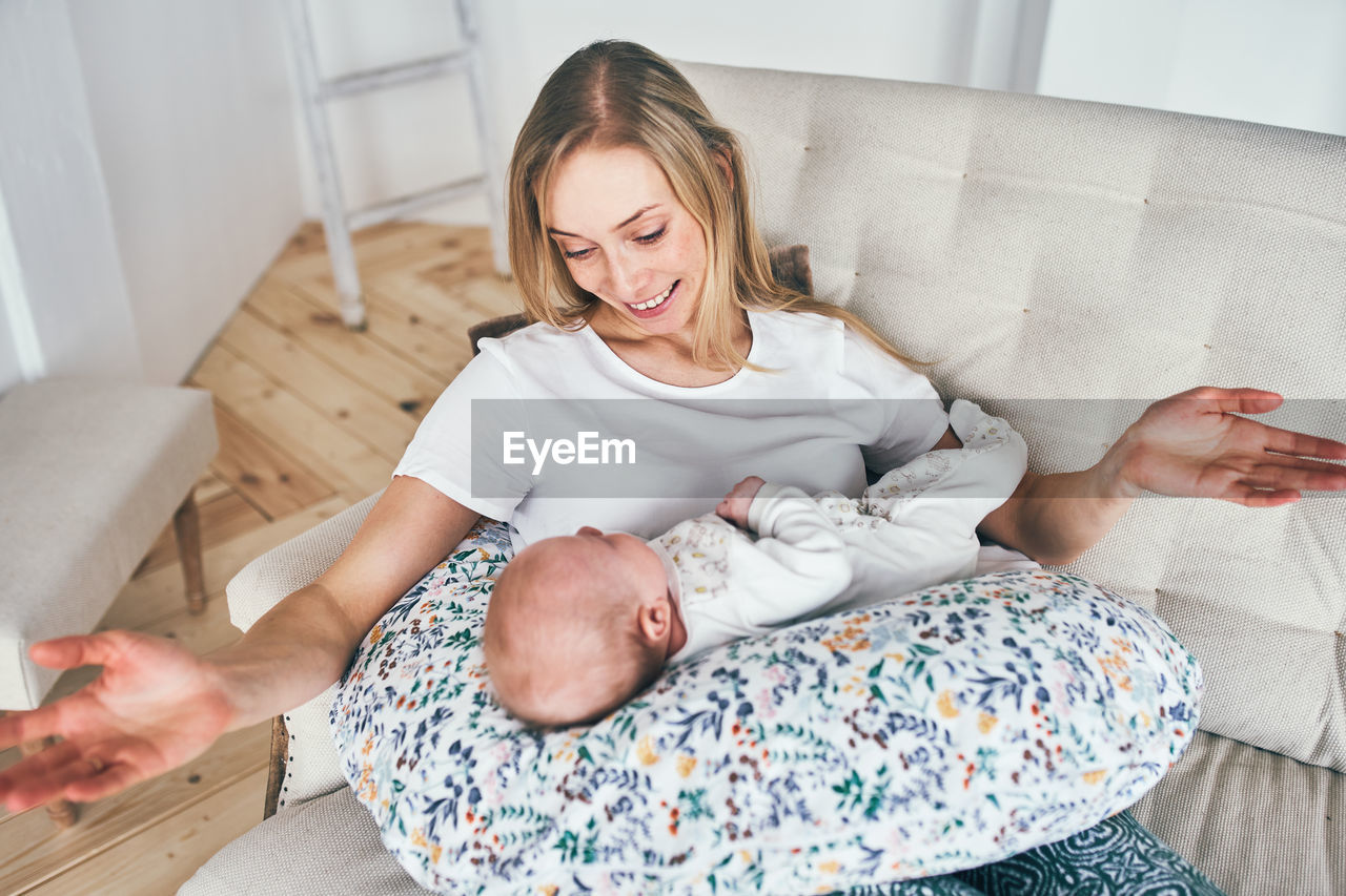 High angle view of smiling mother with baby at home