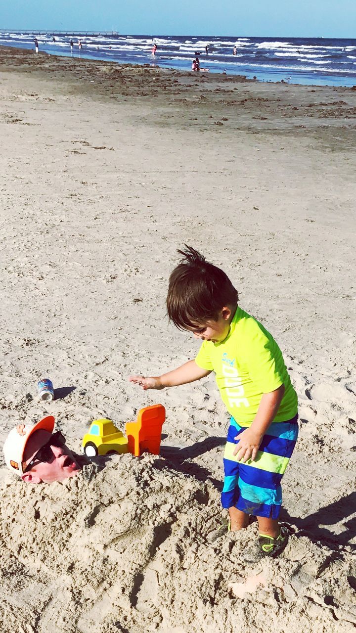 High angle view of boy with father playing at beach