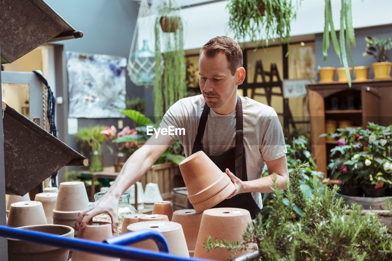 Male mid adult owner arranging terracottas at store