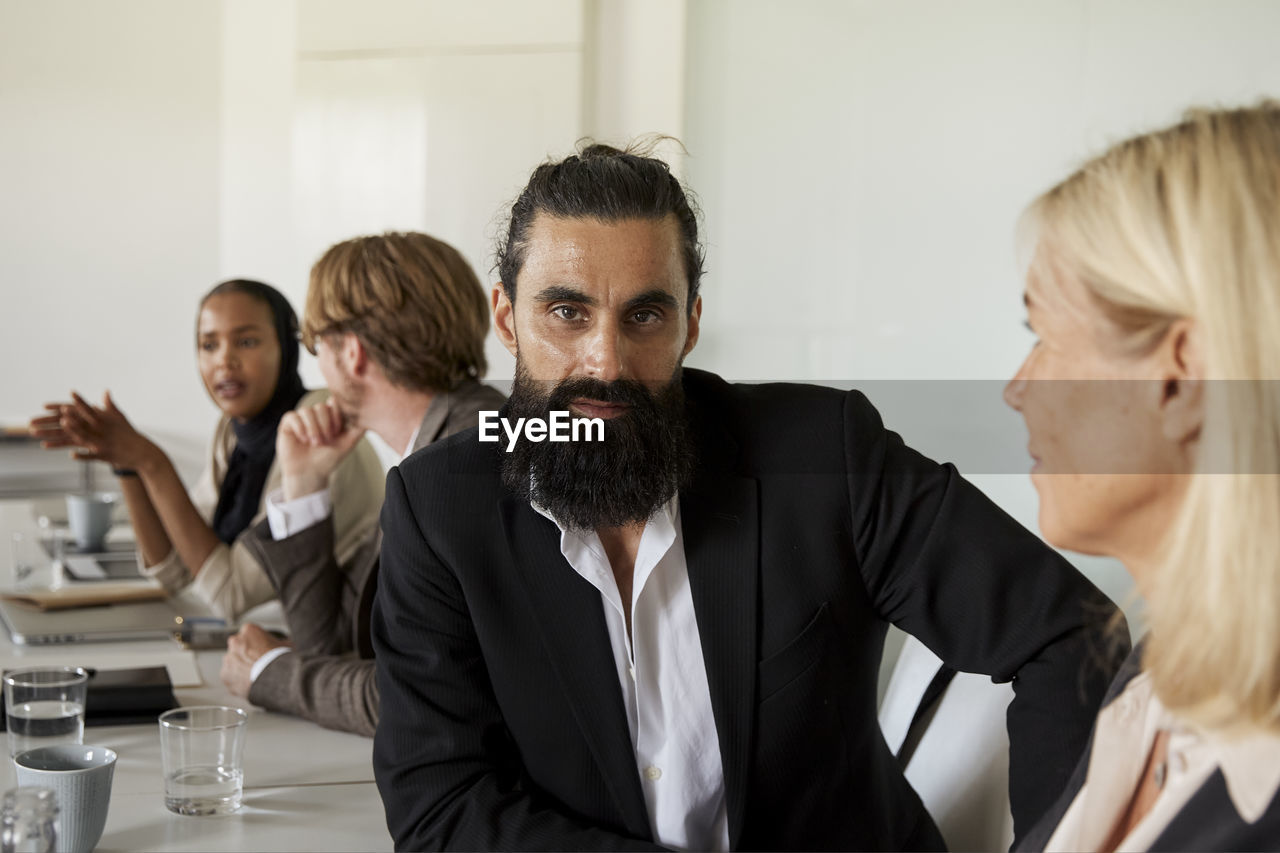Businessman looking at camera during business meeting