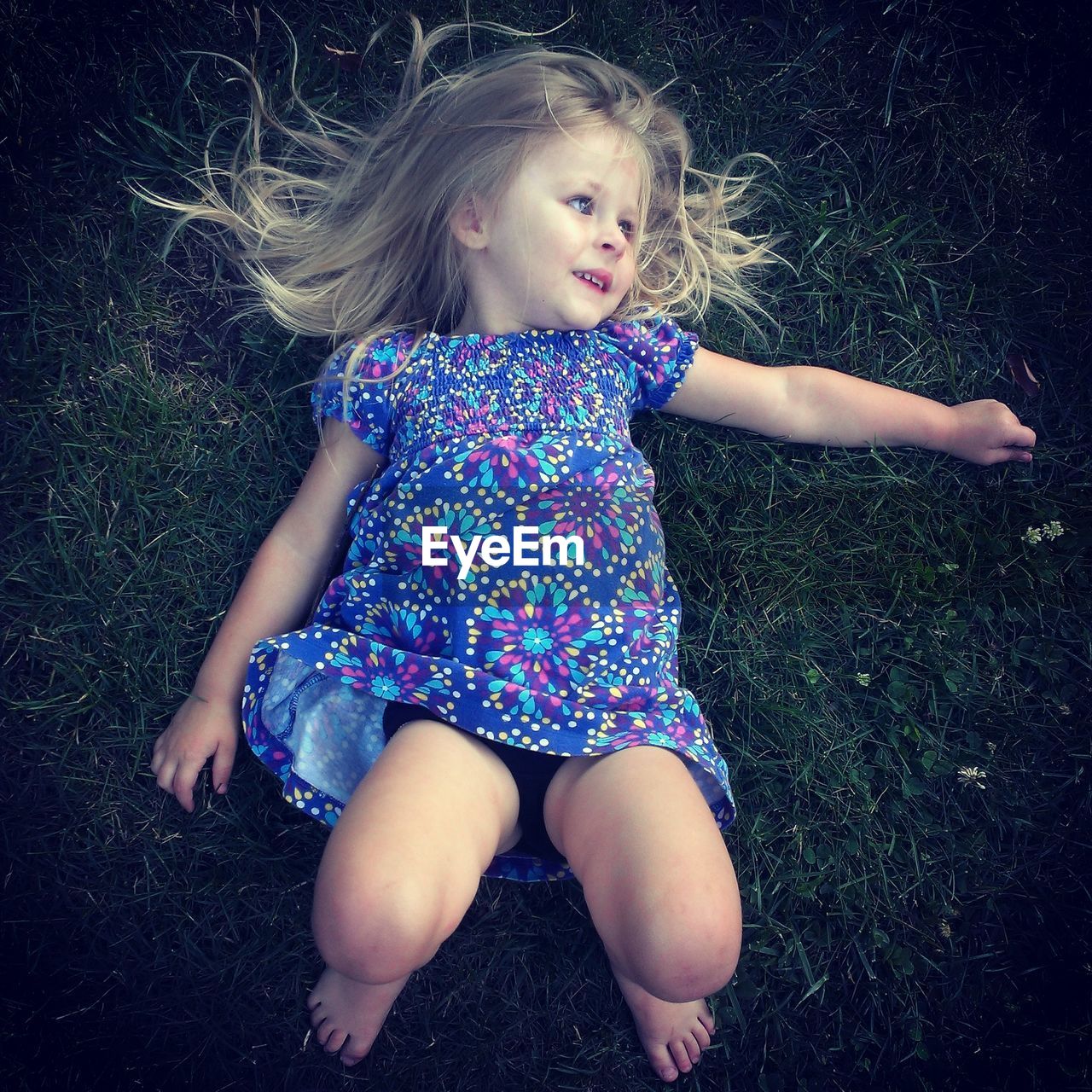 High angle view of a girl lying on grass