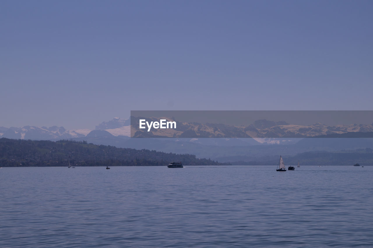 SCENIC VIEW OF SEA BY MOUNTAINS AGAINST SKY