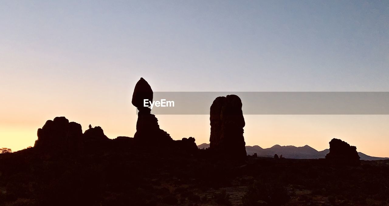 SILHOUETTE OF ROCK FORMATIONS AGAINST SKY