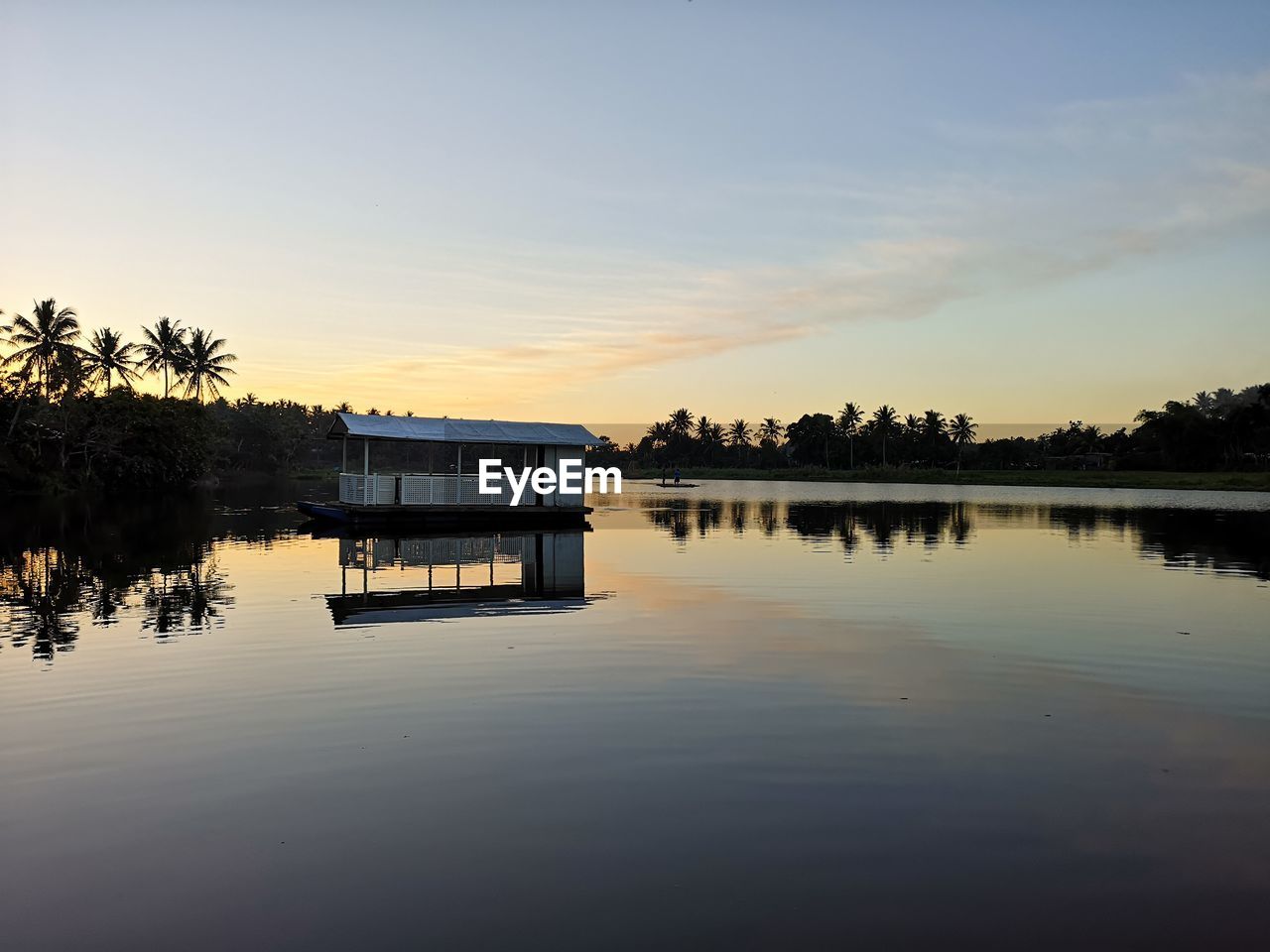 Scenic view of lake against sky at sunset