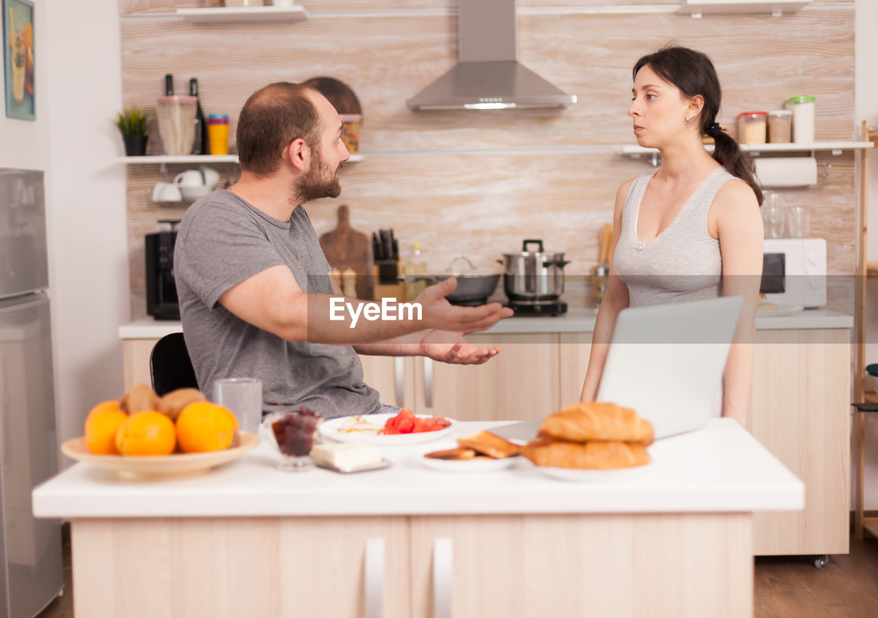 Man and woman standing by food at home