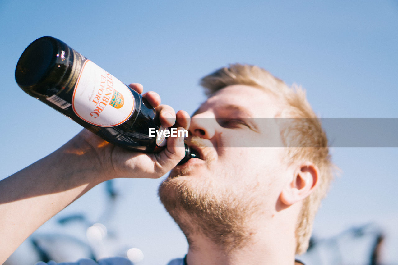 CLOSE-UP PORTRAIT OF MAN DRINKING BEER GLASS