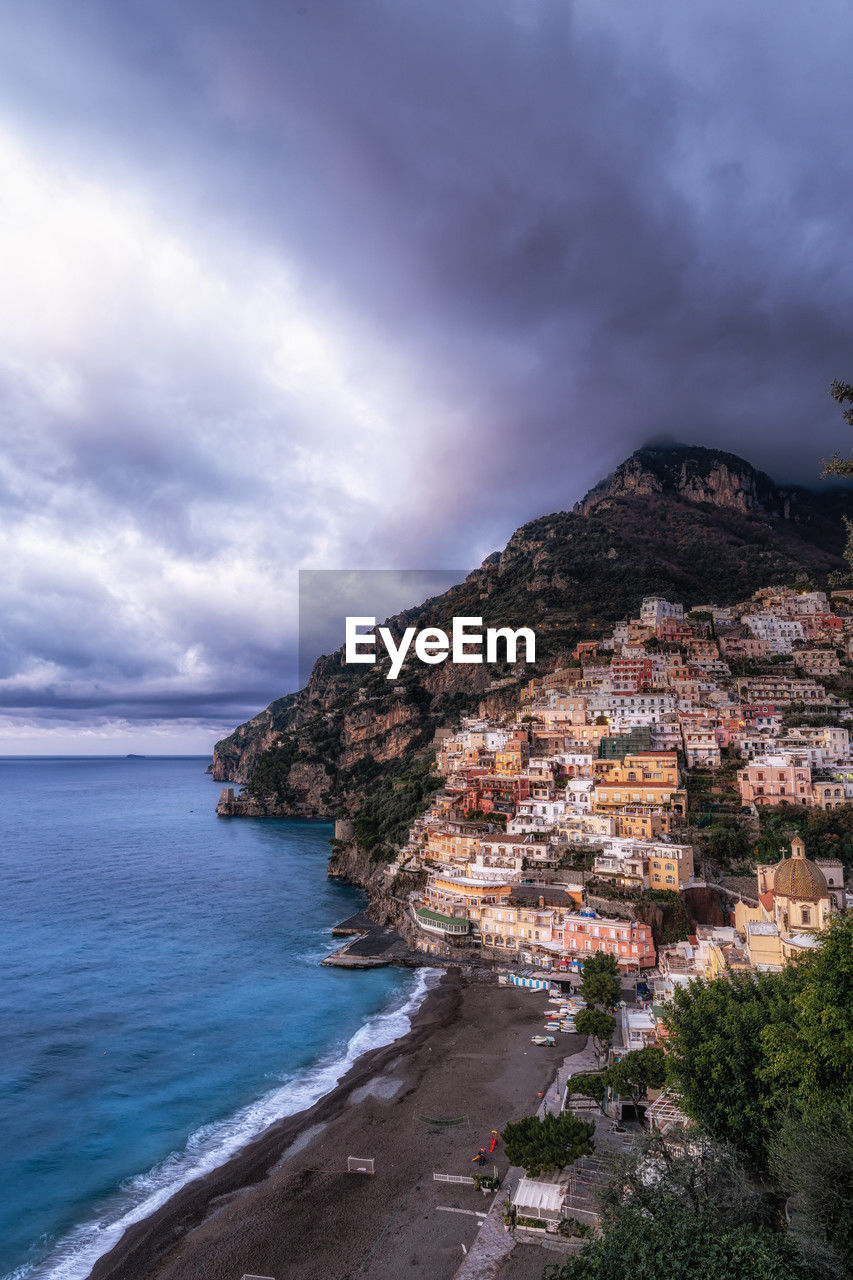 sea, sky, land, water, cloud, coast, beach, ocean, nature, beauty in nature, scenics - nature, travel destinations, architecture, mountain, cliff, body of water, environment, travel, coastline, shore, rock, building exterior, tourism, horizon, terrain, landscape, building, no people, outdoors, city, built structure, holiday, dramatic sky, trip, vacation, tranquility, overcast, seascape, bay, plant, island, tree, storm, tranquil scene, day, cloudscape