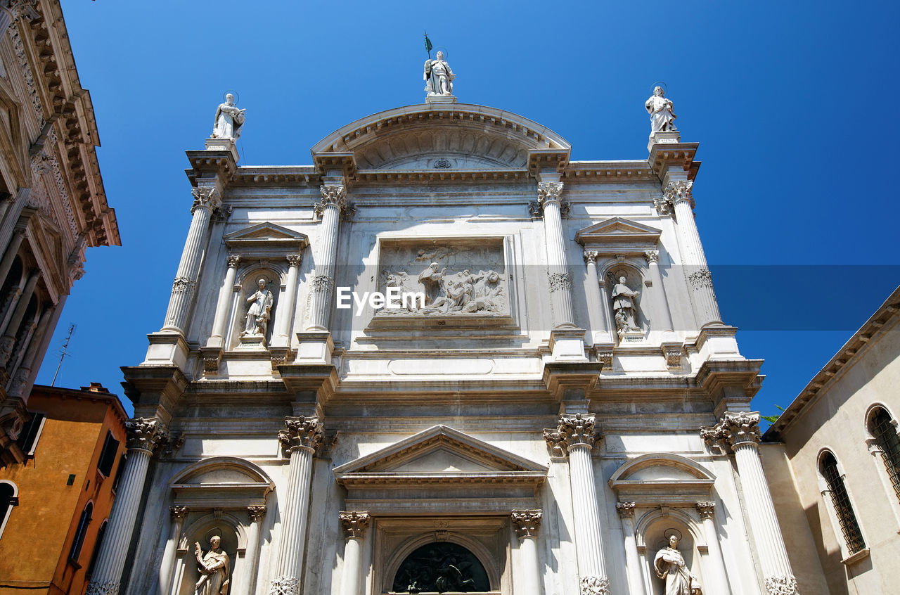 Low angle view of scuola grande di san rocco museum against clear blue sky