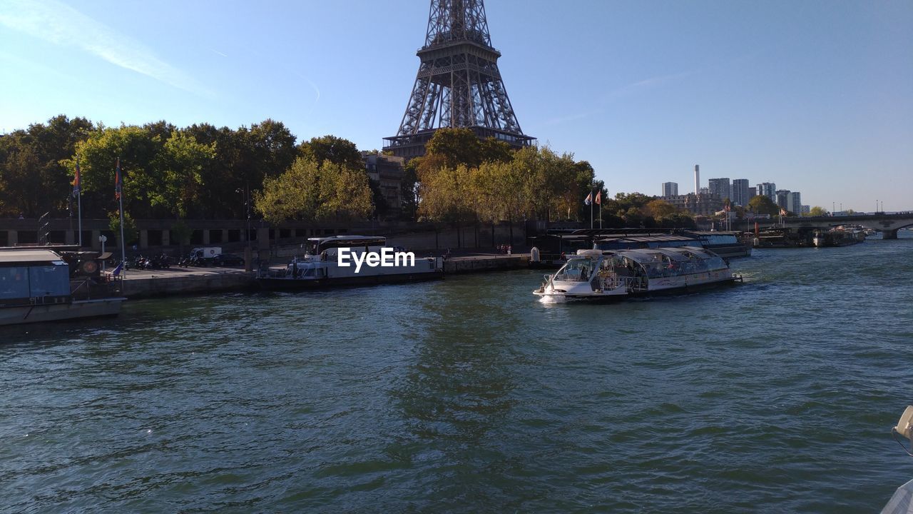 Boat in river against sky in city