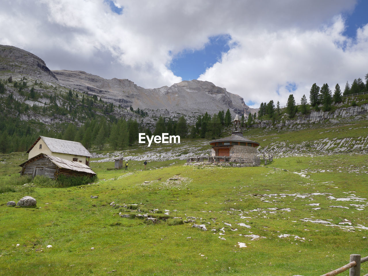 mountain range, mountain, landscape, environment, building, architecture, sky, scenics - nature, meadow, built structure, grass, cloud, building exterior, highland, nature, plant, house, land, wilderness, valley, beauty in nature, plateau, travel destinations, travel, no people, field, plain, hut, residential district, rural area, rural scene, pasture, snow, tourism, tree, village, tranquility, green, grassland, non-urban scene, water, outdoors, activity, tranquil scene, social issues, mountain peak, mountain pass, forest, religion, ridge, cold temperature, history, summer, vacation, day, trip, holiday, idyllic, the past, winter