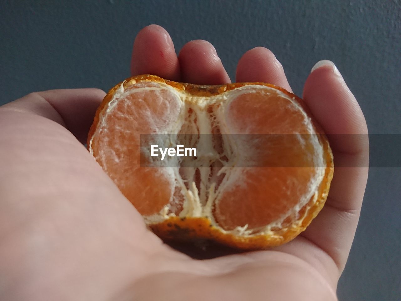 hand, food and drink, food, fruit, one person, orange, healthy eating, holding, citrus, produce, plant, wellbeing, freshness, close-up, clementine, macro photography, indoors, citrus fruit, grapefruit, yellow, tangerine, orange color, studio shot, lifestyles, slice, cross section, adult
