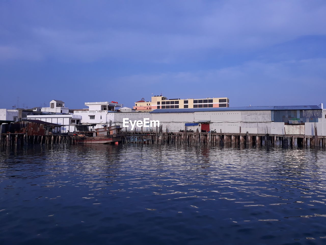 Buildings by sea against sky in city