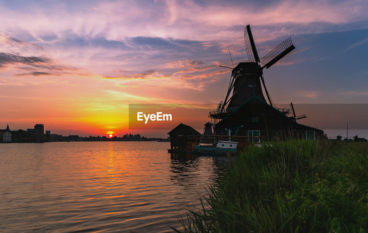 TRADITIONAL WINDMILL AGAINST SKY AT SUNSET