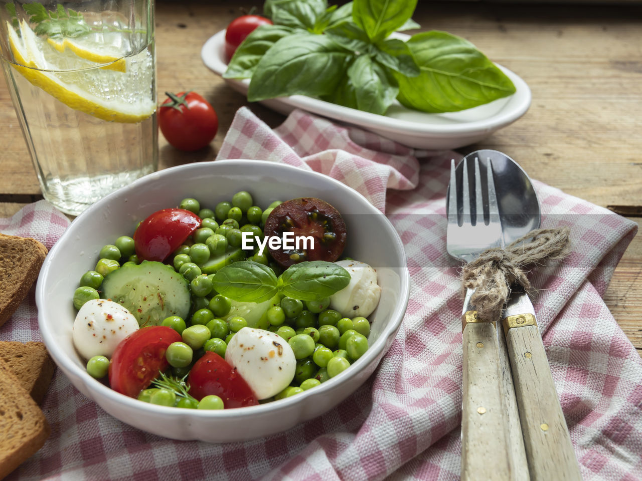 Salad vegetarian. fresh vegetable salad with tomato, cucumber, basil, green peas, mozzarella cheese.