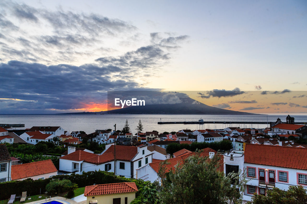 High angle view of townscape by sea against sky