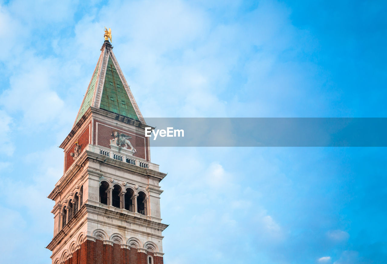 Low angle view of san marco campanile against cloudy sky
