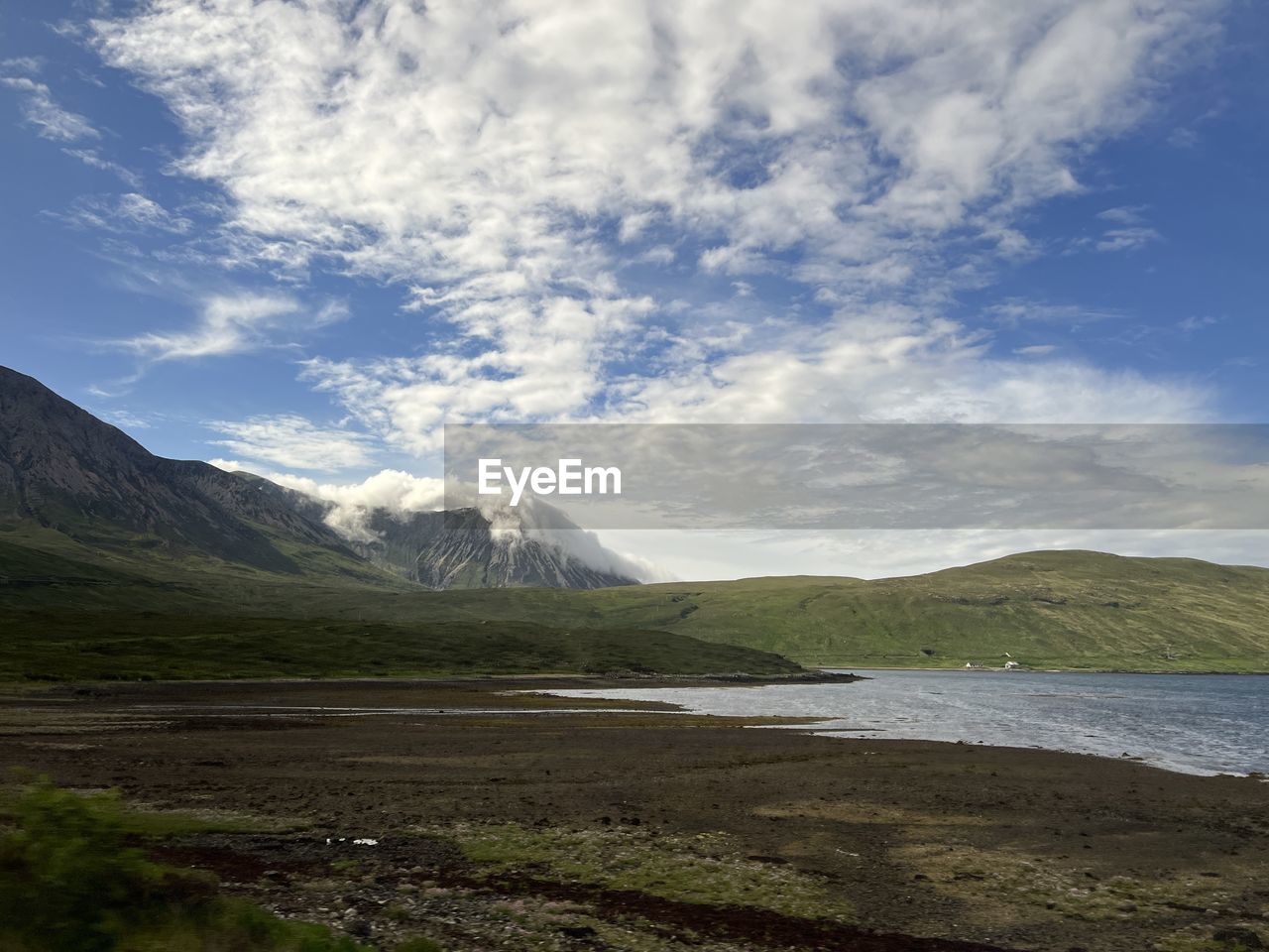mountain, environment, scenics - nature, highland, sky, cloud, landscape, lake, beauty in nature, nature, water, land, mountain range, travel destinations, no people, wilderness, travel, tranquil scene, tranquility, non-urban scene, tourism, plant, day, outdoors, snow, cold temperature, grass, plateau, holiday