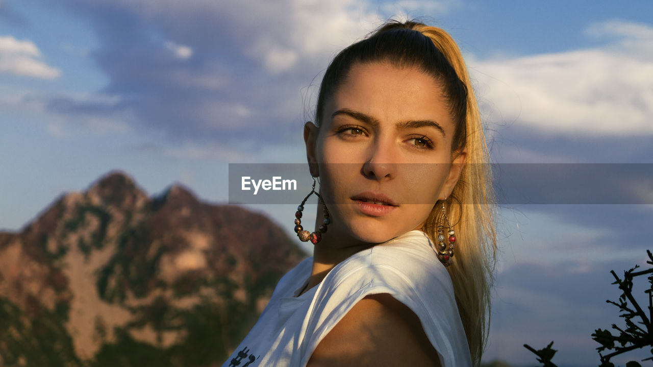 Close-up of beautiful young woman against sky