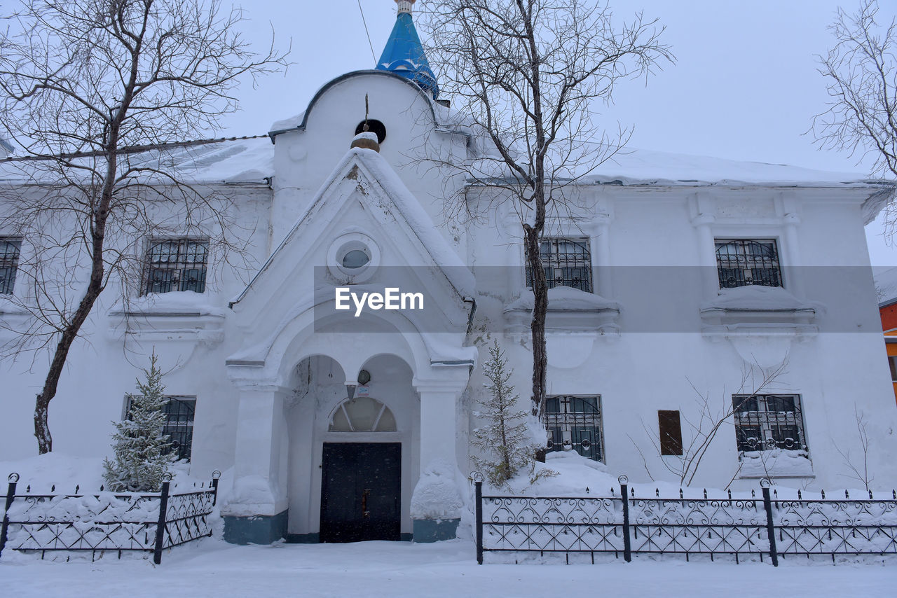 WHITE BUILDING WITH SNOW COVERED TREE