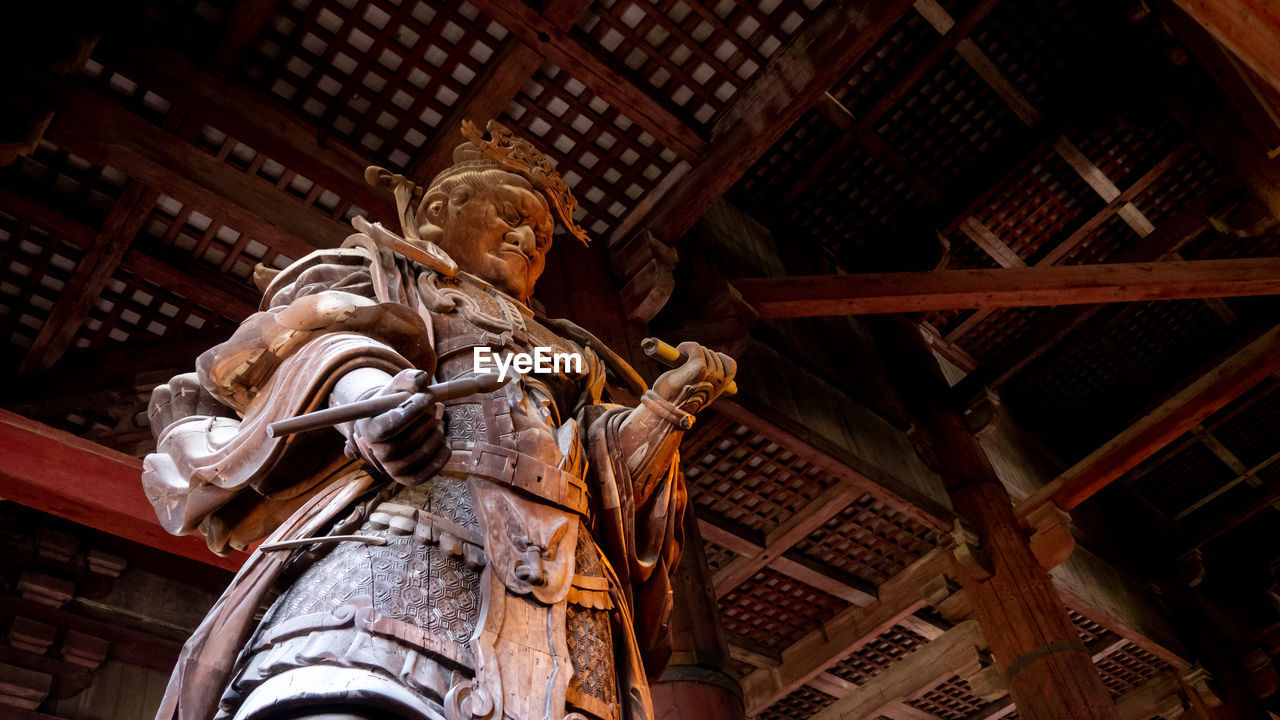 Low angle view of statue against building ceiling