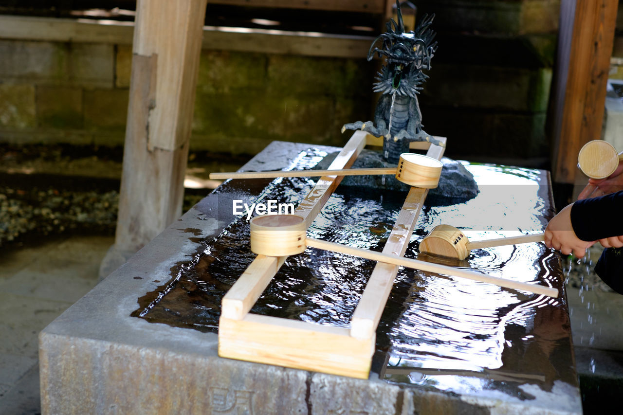 People drinking water from japanese fountain