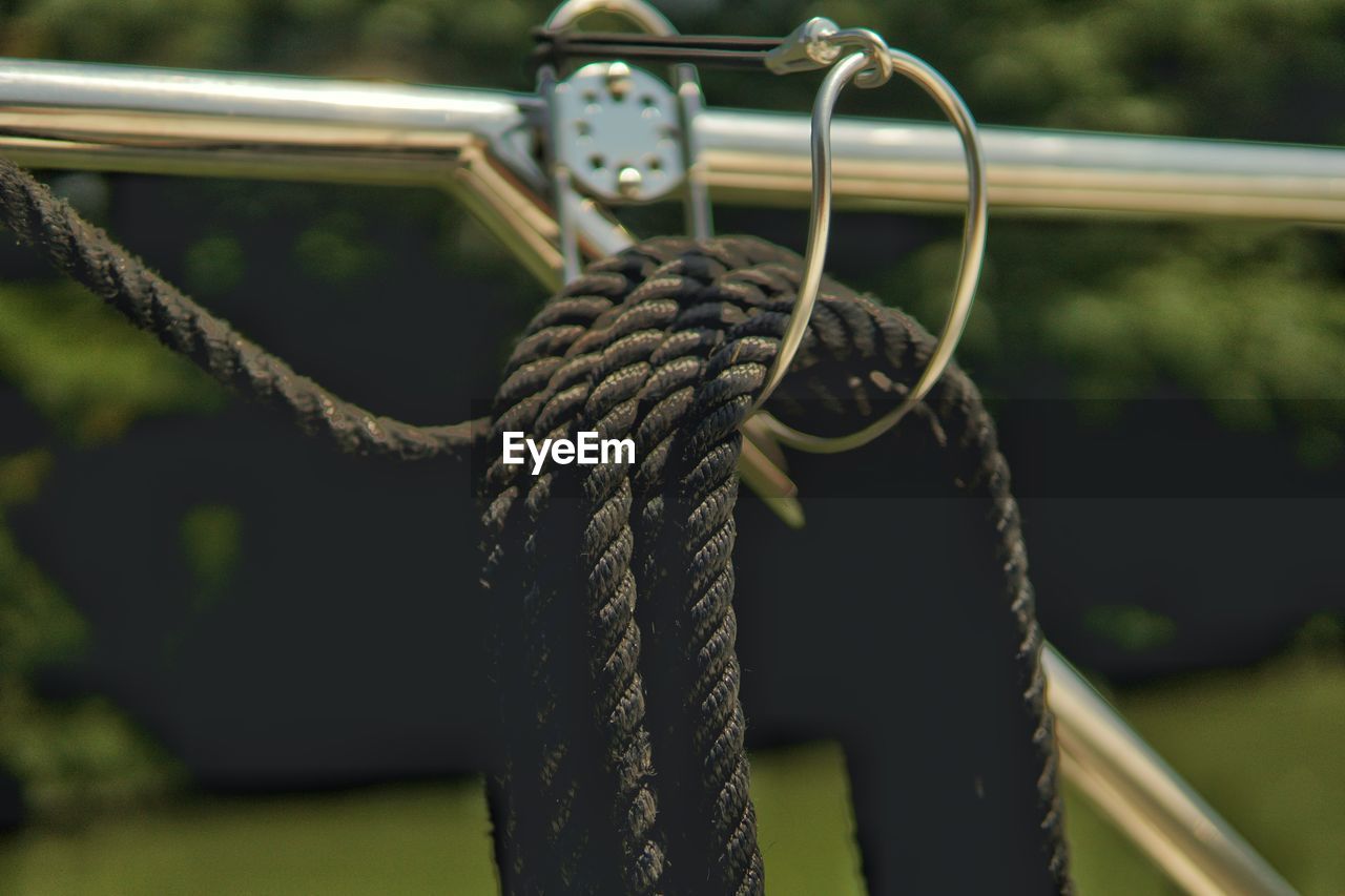 CLOSE-UP OF ROPE TIED UP ON METALLIC STRUCTURE