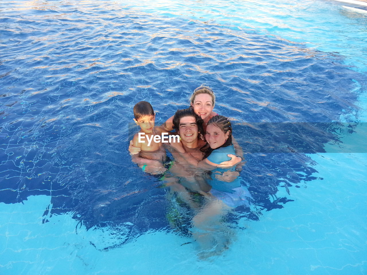 Portrait of happy family enjoying in swimming pool