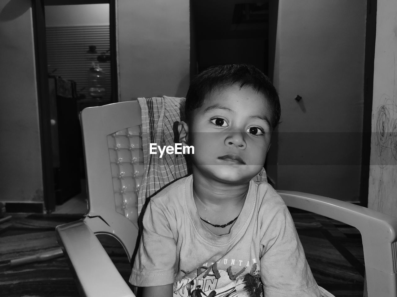 Portrait of boy sitting on chair at home