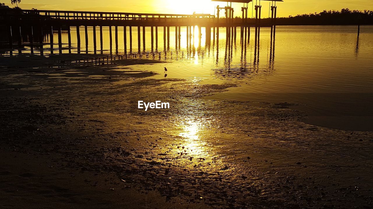 PIER OVER SEA AGAINST SKY AT SUNSET