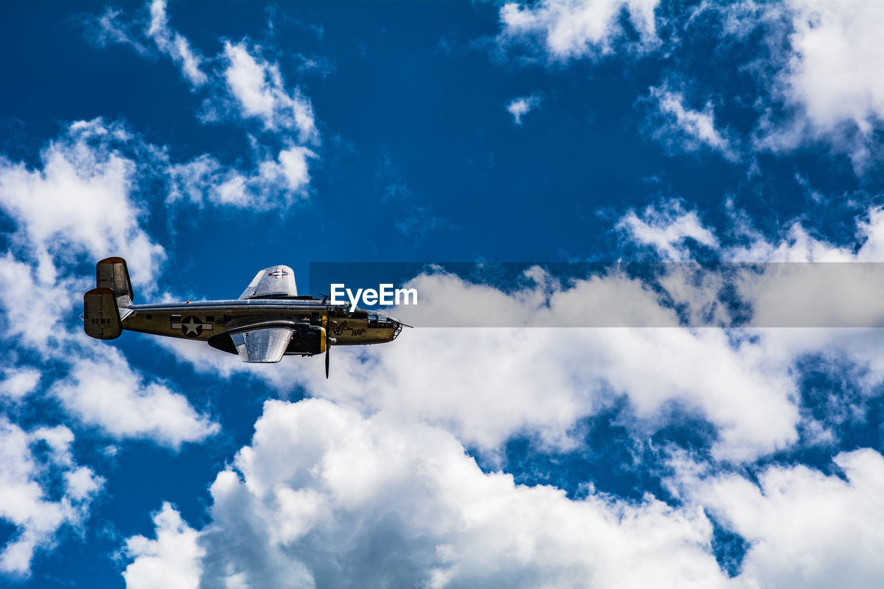 LOW ANGLE VIEW OF AIRPLANE FLYING AGAINST CLOUDY SKY