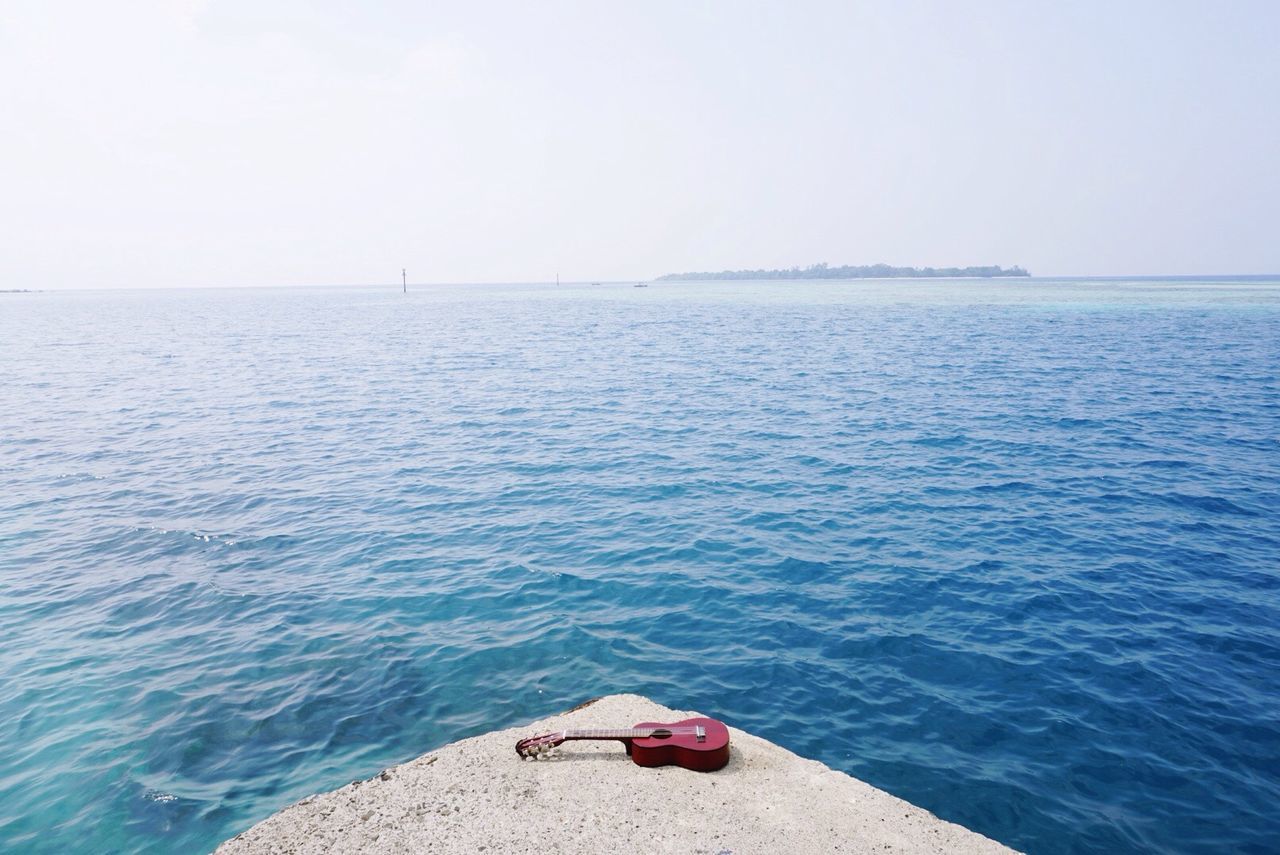 Abandoned acoustic guitar on the seashore