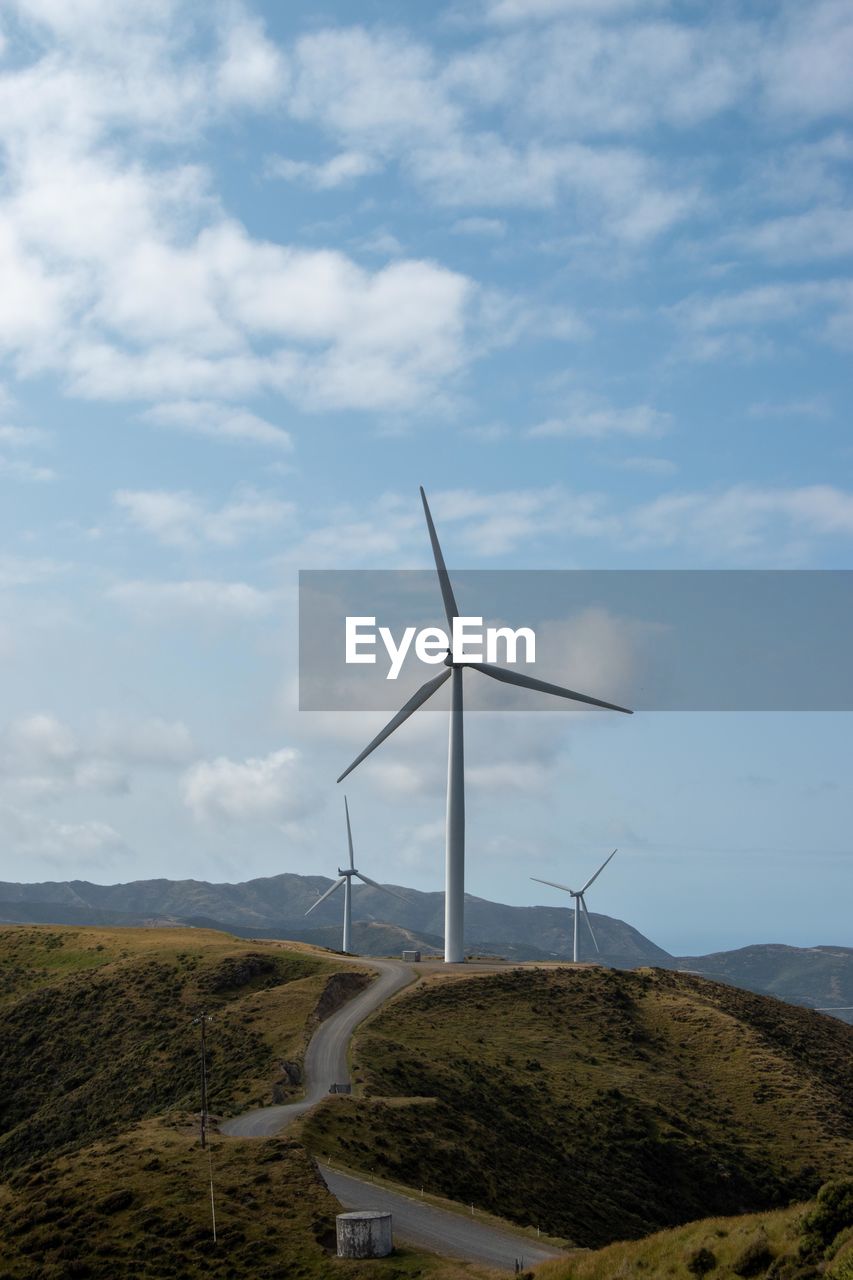WIND TURBINES ON LAND AGAINST SKY