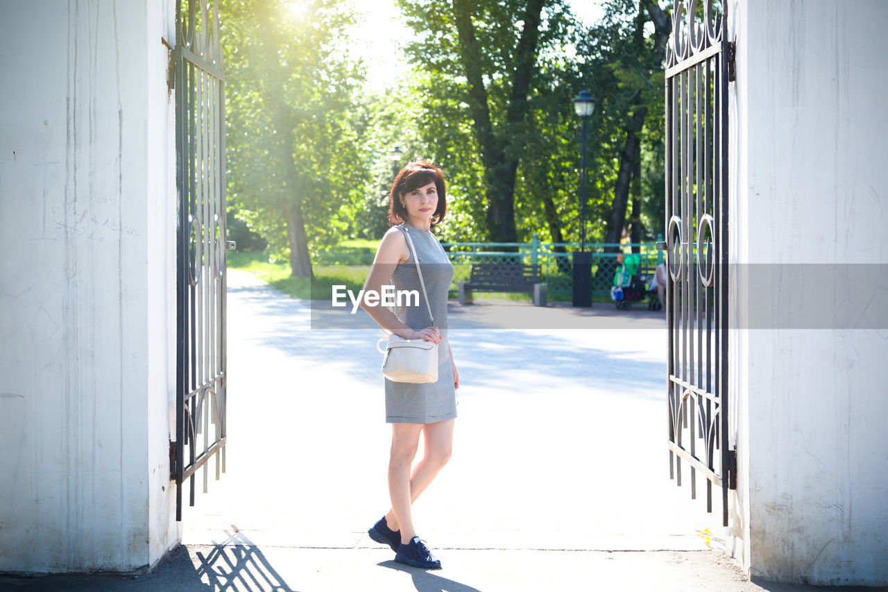 Full length of woman standing against wall