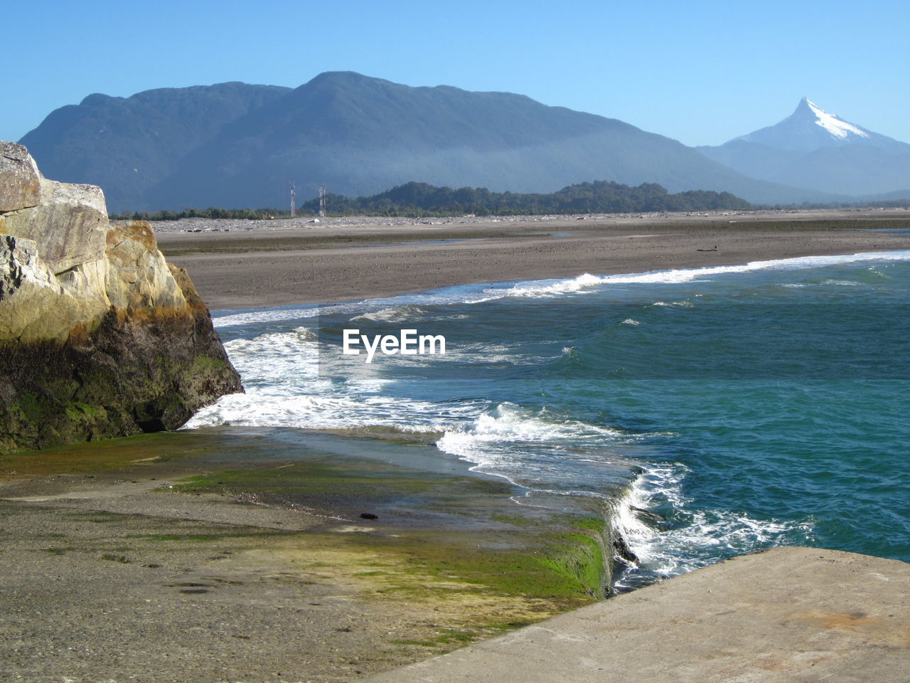 View of calm beach against mountain range