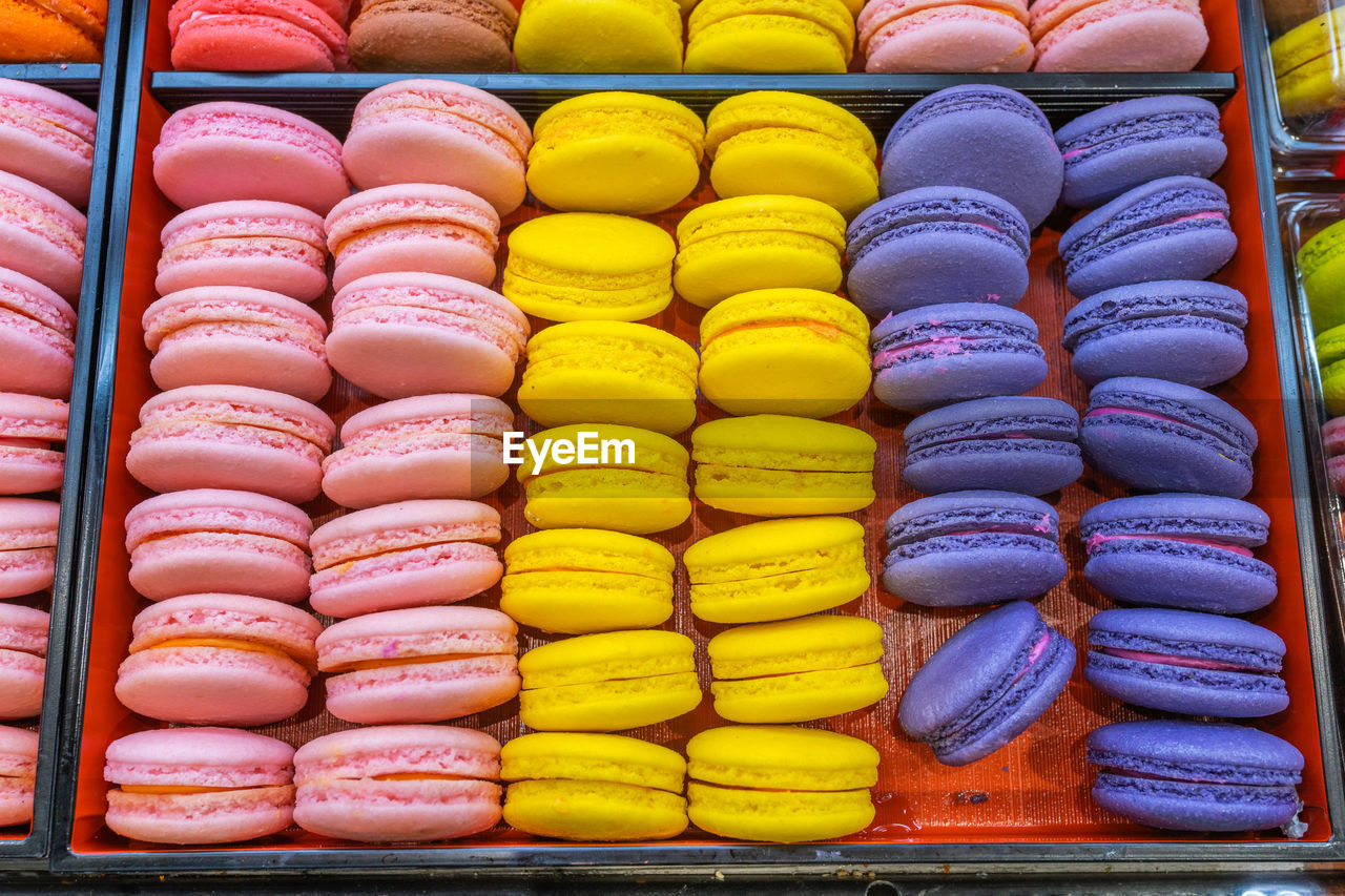 Pile of colorful macaroon cakes in tray at patisserie