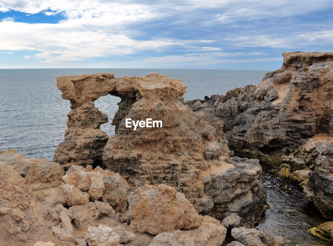Rock formation by sea against cloudy sky at cape peron