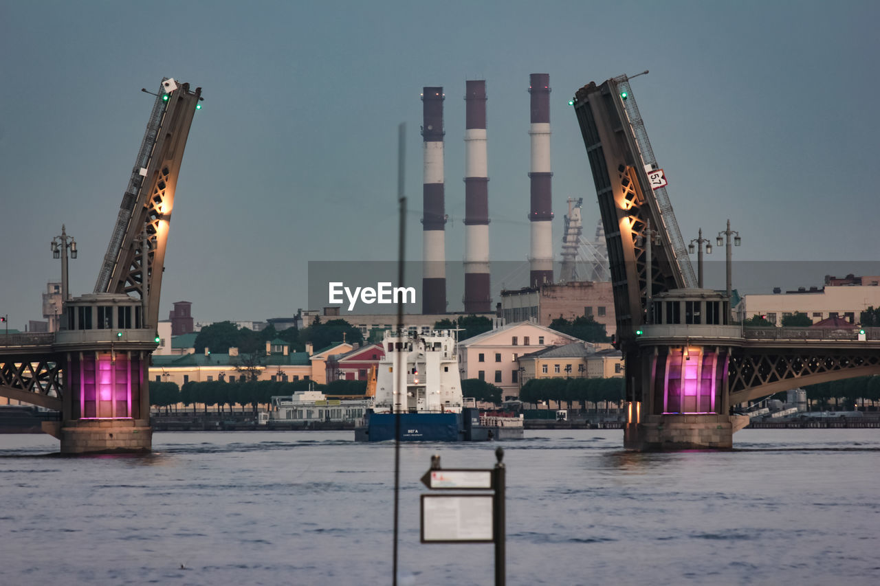 Bascule bridge over river against buildings in city