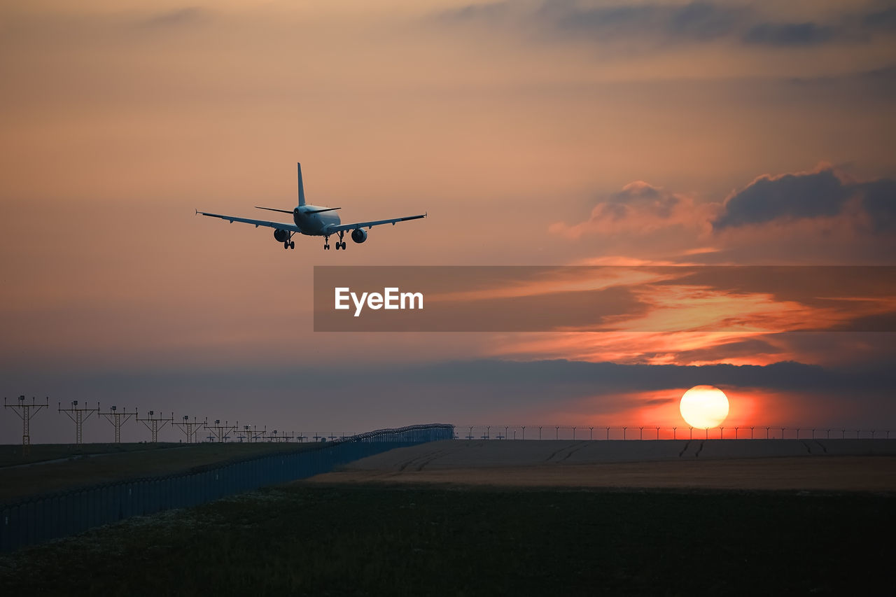 Airplane landing on airport runway at beautiful sunset. themes travel and aviation.