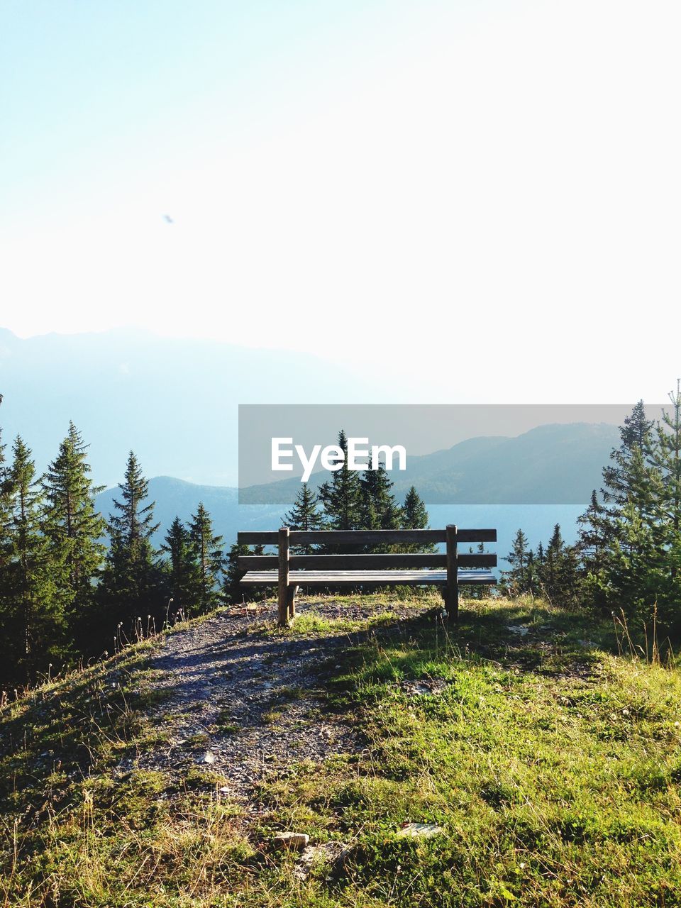 Empty bench on hill against mountain