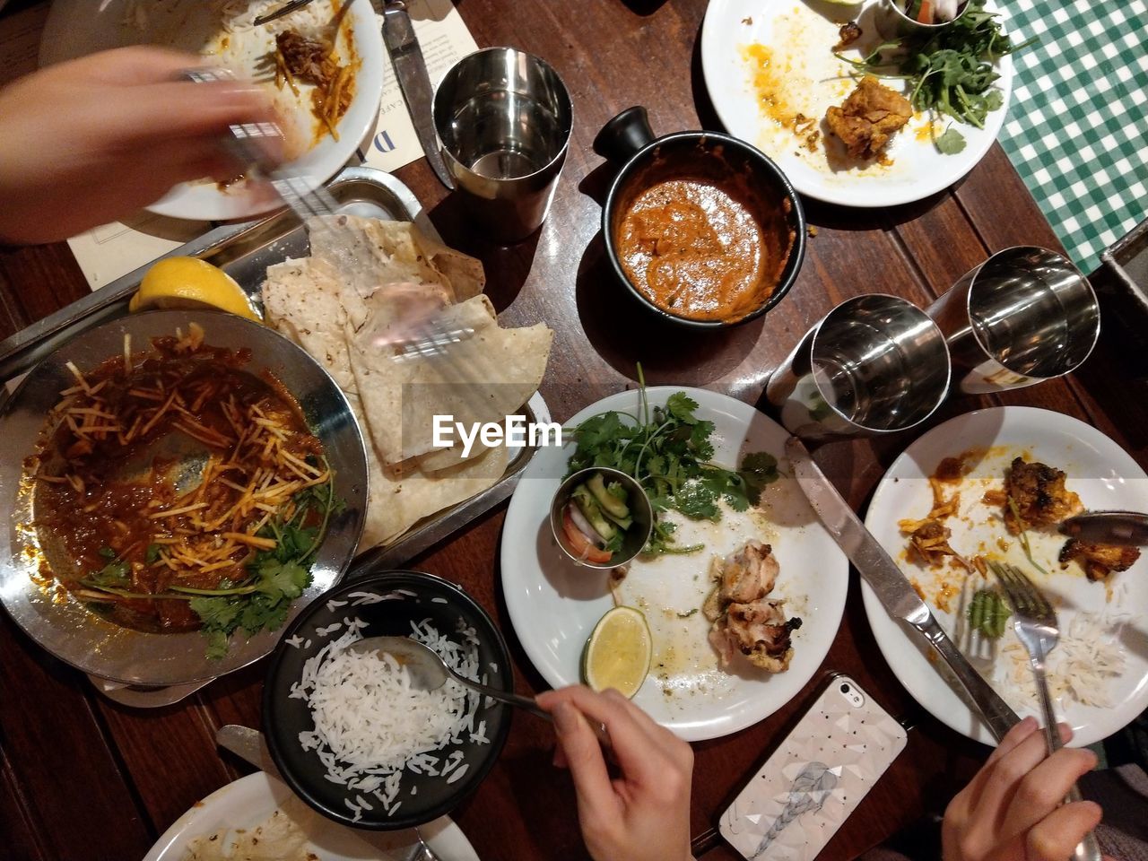 Cropped hands of people having food at dining table in restaurant