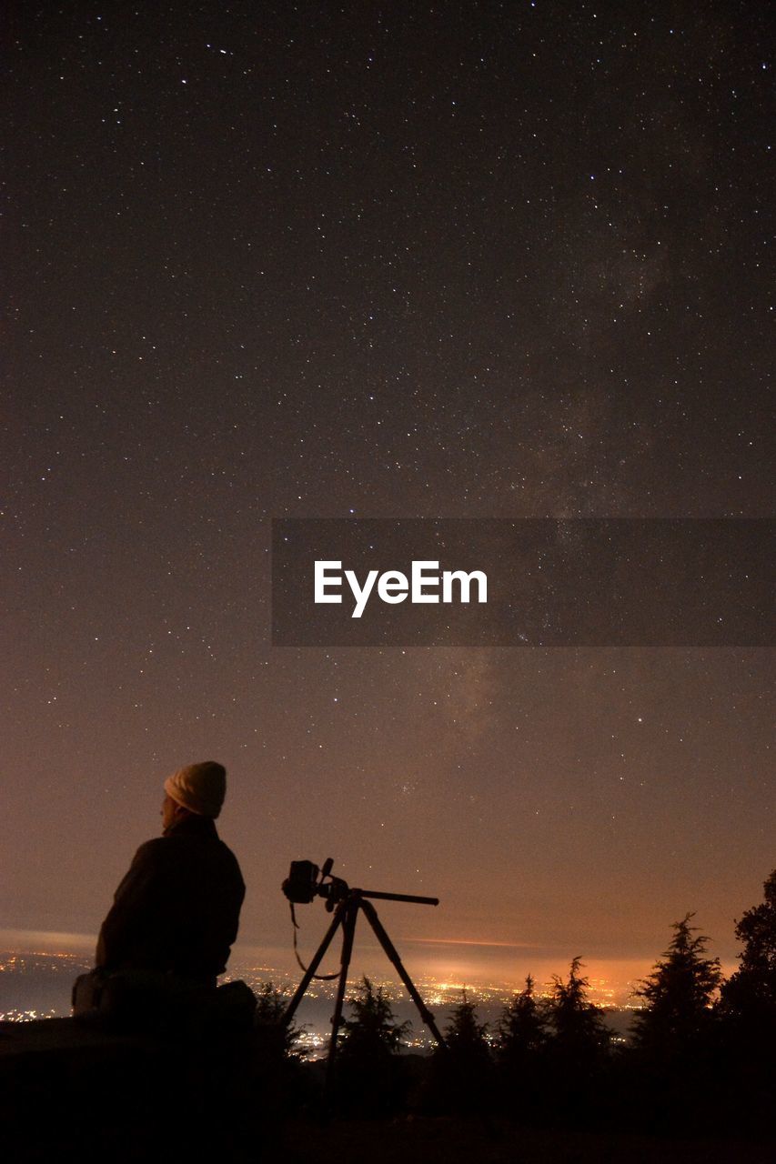 Man standing against star field at night