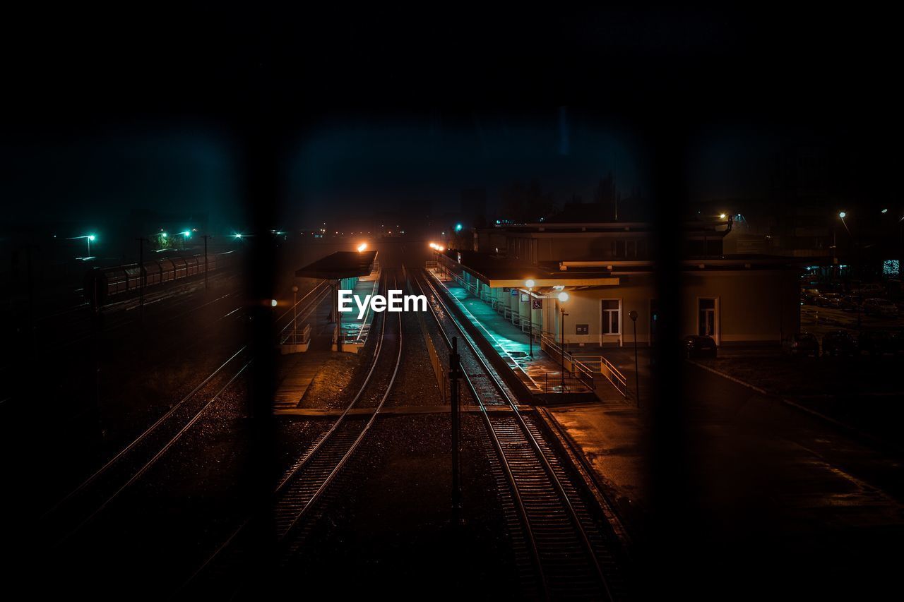 Railroad station seen through railing at night