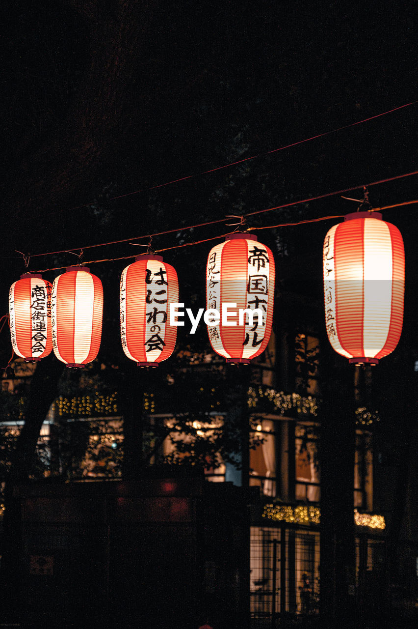night, lighting equipment, illuminated, lantern, chinese lantern, hanging, text, communication, light, no people, architecture, lighting, darkness, built structure, red, low angle view, sign, building exterior, chinese new year, chinese lantern festival