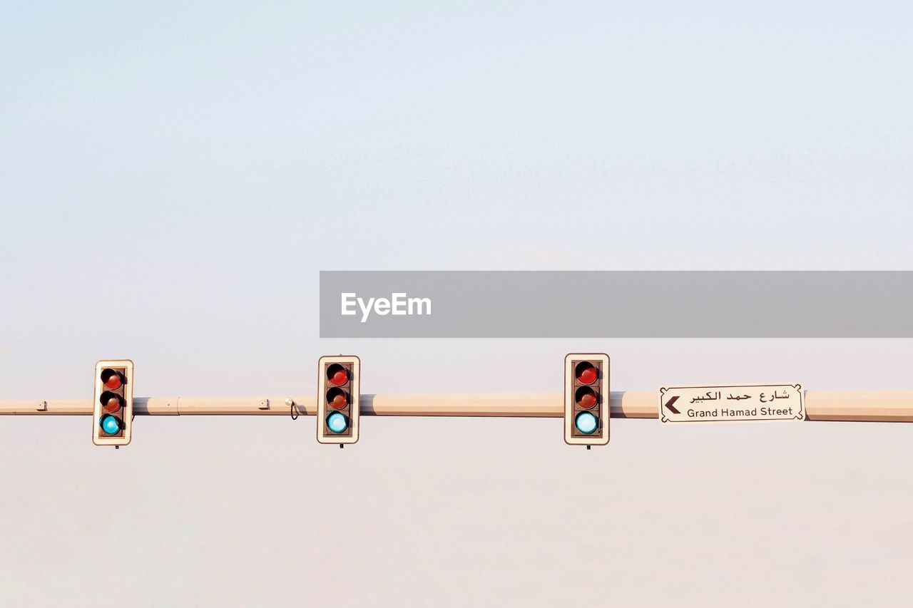 Low angle view of road signal against clear sky