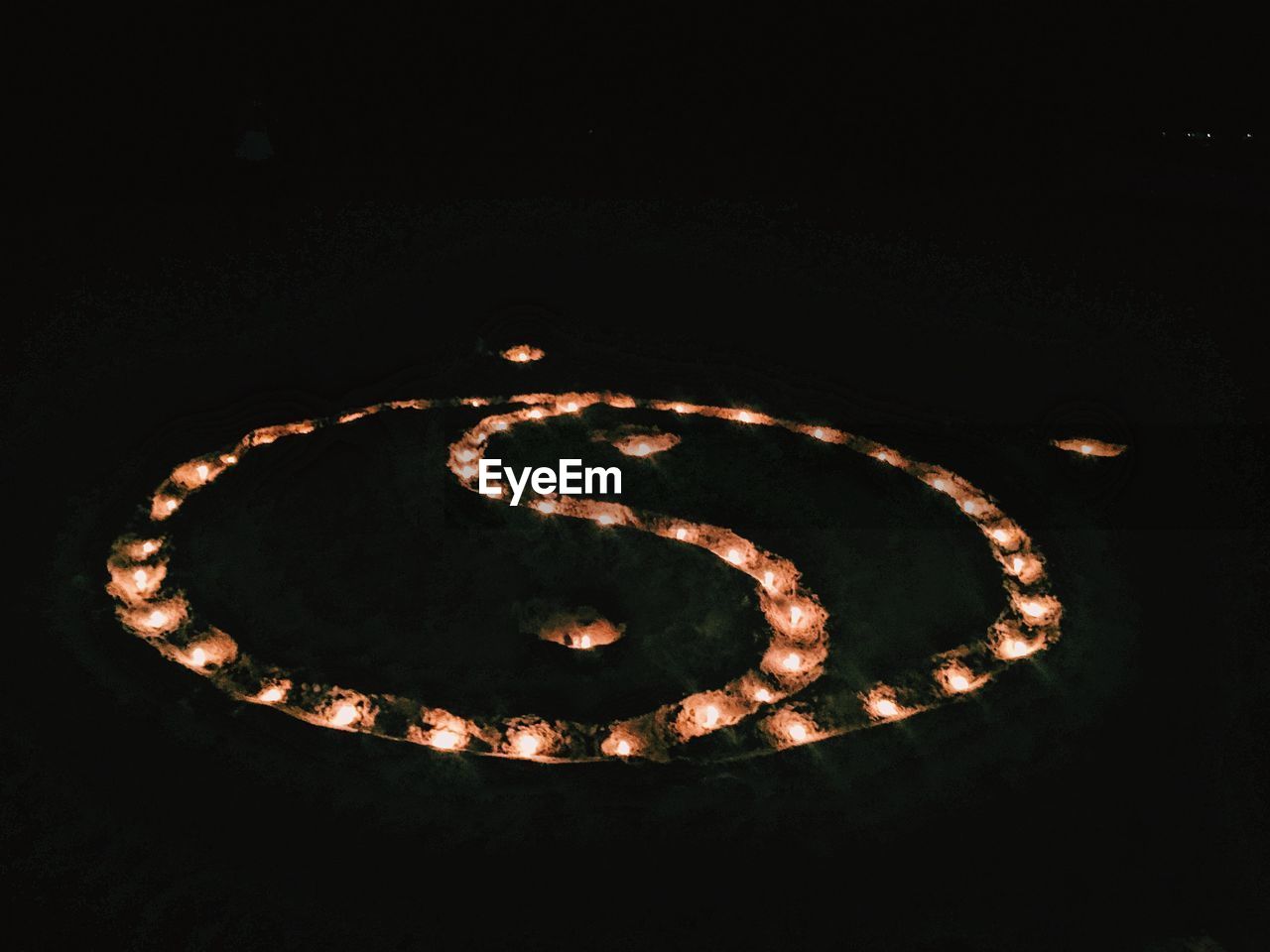 High angle view of illuminated yin yang symbol in dark at night