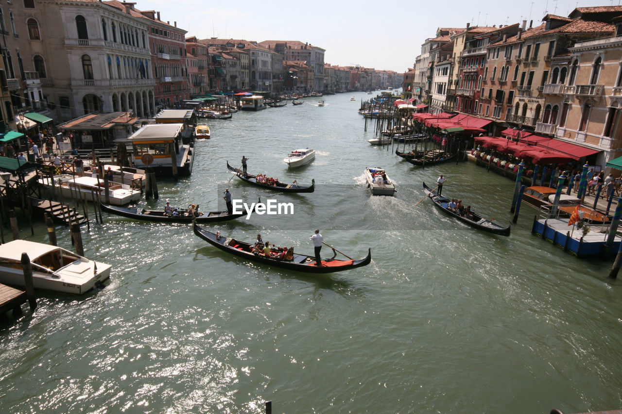 High angle view of boats on canal amidst buildings