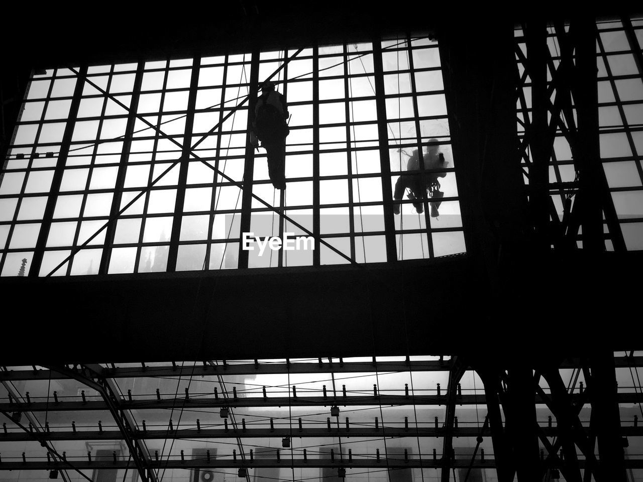 Low angle view of people cleaning glass at railroad station